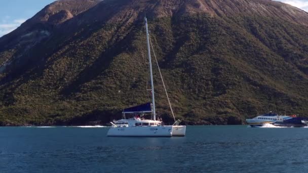 Fehér katamarán, komp és sétahajó hajózik a Földközi-tengeren. Lipari szigetek, Szicília, Olaszország — Stock videók
