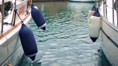 Portorosa marinasında demirleme çamurlukları olan iki beyaz yelkenli yat.