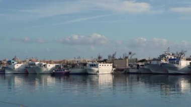 Portorosa marinasında dalgakıran yakınlarında demirlemiş renkli gemiler ve tekneler.