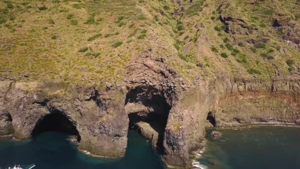 Vue aérienne sur un bateau de plaisance blanc avec des personnes à bord ancrées près des grottes de l'île de Lipari dans la mer Méditerranée. Sicile, Italie 