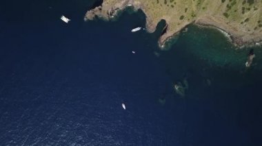 Akdeniz 'de demirlemiş gemiler, kayalar ve binaları olan Lipari Adası' nın dağları. Mavi gökyüzü, ufukta. Sicilya, İtalya