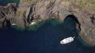 Zevk teknesindeki hava manzarası, Akdeniz 'de yüzen insanlar, kayalar ve Lipari Adası' nın dağları. Güneşli bir gün. Sicilya, İtalya