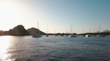 Lipari Adası 'nın deniz kıyısındaki hava manzarası. Yeşil ağaçlar ve binalar. Dağlar ve mavi gökyüzü. Yatlar, katamaranlar ve tekneler. Sicilya, İtalya