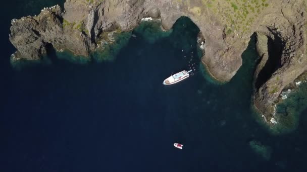 Vista aérea en barco de recreo anclado, gente nadando en el mar Mediterráneo, rocas y montaña de la isla de Lipari. Día soleado. Sicilia, Italia — Vídeo de stock