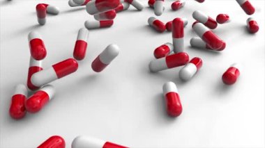 Kırmızı ilaç kapsülleri beyaz arka plandaki yığının üzerine düşüyor. Parlak yakın plan 3B görüntüleme.