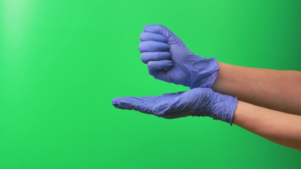 Doktor posypuje dużo tabletek do dłoni przeciwko zielonemu ekranowi. Lekarze kobieta ręka w niebieskiej rękawicy ochronnej zbliżenie. — Wideo stockowe
