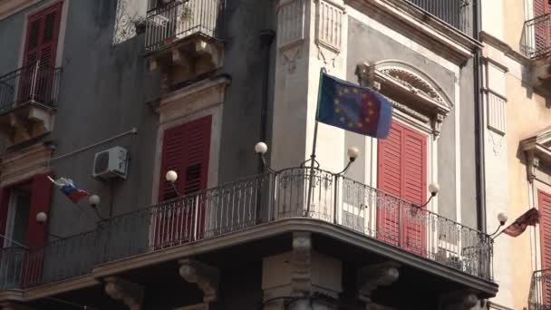 CATANIA, SICILY, ITALIË - SEPT, 2019: Oud gebouw, prachtige lantaarns, balkon met vlaggen. Langzame beweging — Stockvideo