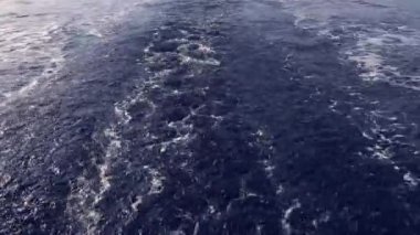 Deniz yüzeyinde köpüklü dalgalar bırakan motorlu tekne.