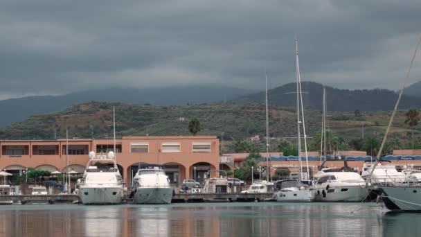 White sailing yachts at marina Portorosa, Furnari, Italy. Mountains, overcast — Stock Video