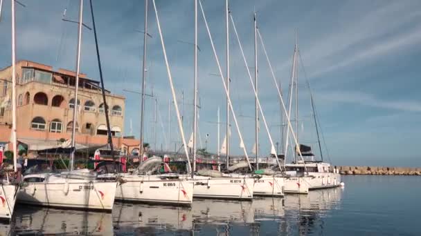 FURNARI, SIZILIEN, ITALIEN - SEPT 2019: Vertäfelte Yachten, Katamarane und Ausreißer. Marina Portorosa Mole mit Bergblick — Stockvideo