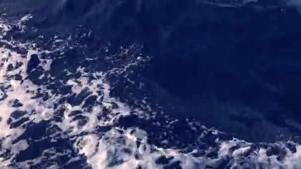 Vista desde el yate en movimiento sobre olas espumosas, montañas y cielo — Vídeos de Stock