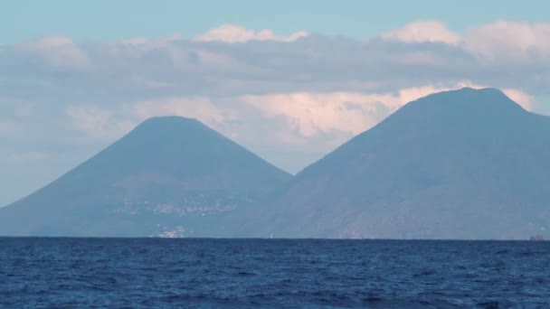 Två höga berg i dimma, vit segelbåt seglar i havet — Stockvideo