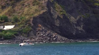 Gemide deniz kıyısına yakın yelkenli insanlarla mekik. Güneşli bir gün