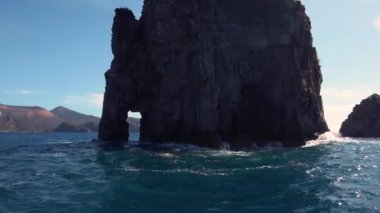 Dalgalar kapı şeklinde bir delikle kaya üzerinde kırılıyor.