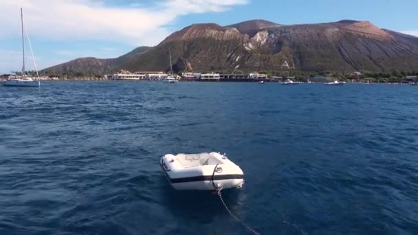 FURNARI, SICILIA, ITALIA - SEPTIEMBRE, 2019: El barco de goma inflable está atado al yate, flotando detrás de él — Vídeos de Stock