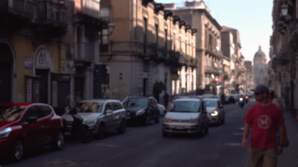CATANIA, SICILIA, ITALIA - SEPTIEMBRE, 2019: Movimiento borroso, calle concurrida de cente histórico. Edificios antiguos. Coches estacionados y en movimiento, scooters. Turistas ambulantes — Vídeos de Stock