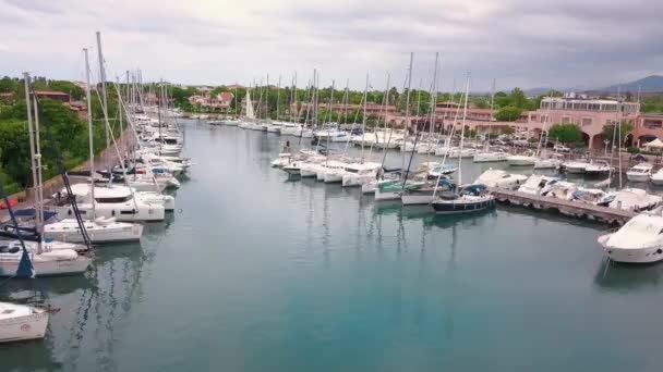 Aerial view on white sailing yachts at Portorosa, Furnari, Italy. Mediterranean sea, mountains and cloudy sky. Buildings, green trees — Stock Video