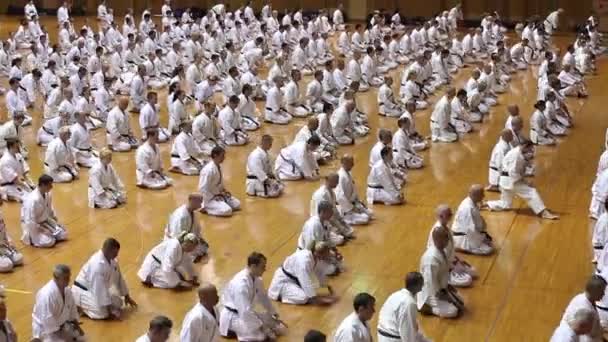 Okinawa, Japón - 11 de julio de 2012: IOGKF World Budo sai. Grupo de personas que practican karate sentado . — Vídeos de Stock