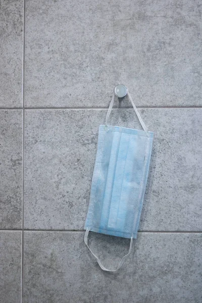 Banyo terazisinde asılı tıbbi bir maske.