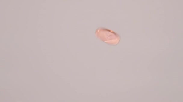 Vue de l'oeil d'un ver d'un penny britannique tournant au ralenti 