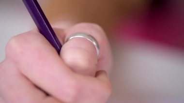 A close up handheld shot of a designer using a pencil n a sketchbook