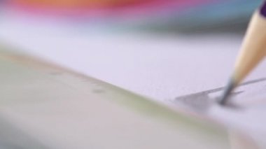 A handheld close up of a pencil drawing in a sketchbook in slow motion