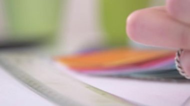 A slow motion tracking shot of someone sketching designs in a sketchbook at a desk