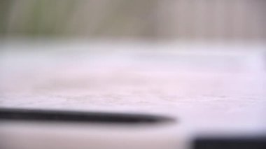 Bir kadın mutfak yüzeyine koyu, sulu yaban mersini döker. Meyve yavaş çekimde masaya doğru yuvarlanıyor ve son kareyi dolduruyor..