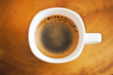 Kahve fincanı ve çay tabağı ahşap bir masada..