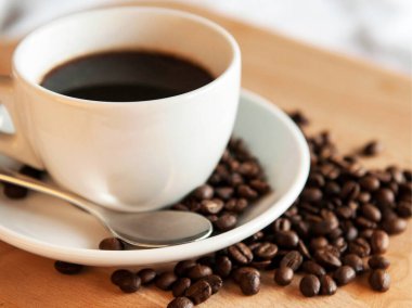 Kahve fincanı ve çay tabağı ahşap bir masada..