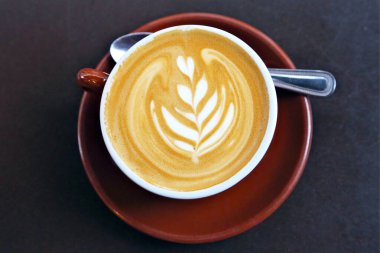 Ahşap arka planda desenli bir fincan kahve.