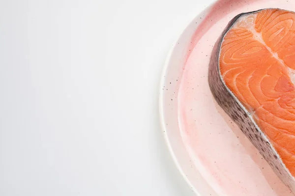 A part of raw salmon steak on a plate — Stock Photo, Image