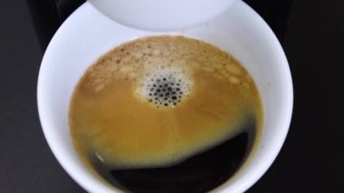 Kahve makinesinin son damlaları kahve demlerken beyaz bir fincana, kahve demlerken, yavaş çekimde.