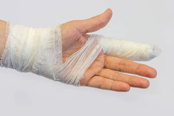Sol elinde bandajlı işaret parmağı olan beyaz arka planda, avuç içinin bir kısmını gösteren bir kadın eli var.