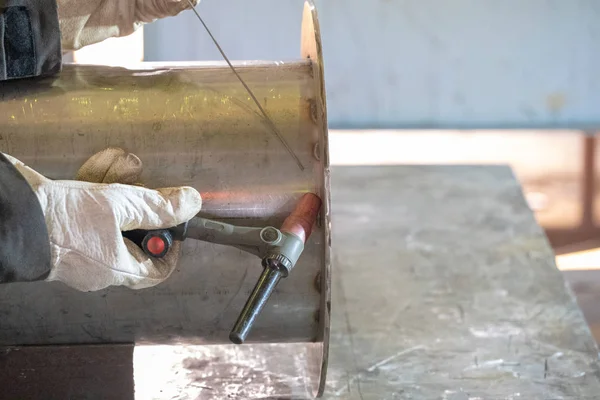 Welding of stainless steel pipe by electric arc welding in argon shielding gas. TIG welding.