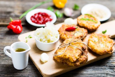 Ahşap arka plan üzerinde malzemelerle Breadboard üzerinde Patates Pancakes