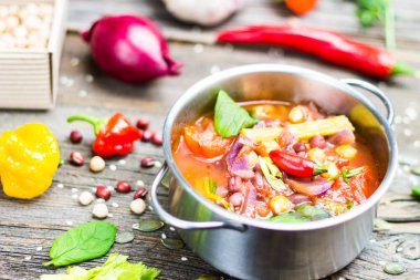 Nohut ve malzemeler ahşap masa üzerinde pişirme ile tencerede Adzuki fasulyesi ile sebze çorbası.