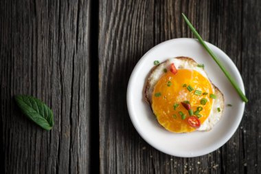 Sahanda yumurta Chives ve fesleğen yaprak beyaz plaka üzerinde