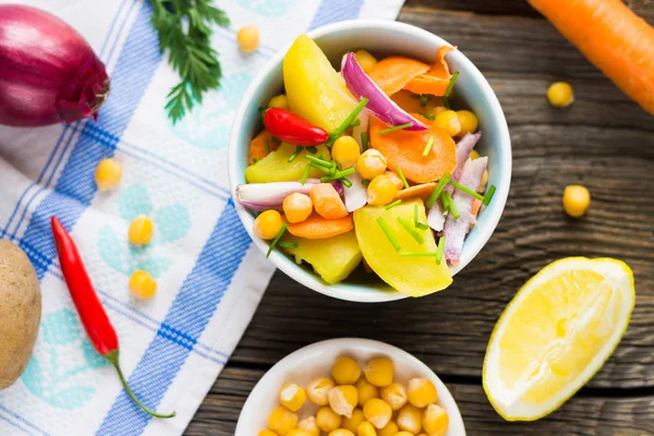 Üstten Görünüm nohut masa örtüsü ve ahşap arka plan üzerinde sebze salatası.