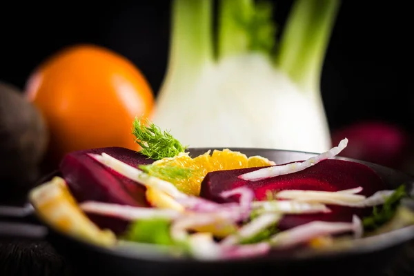 Biyo çiğ sebze gıda. Pancar, soğan Portakal ve rezene dilimleri koyu arka plan üzerinde