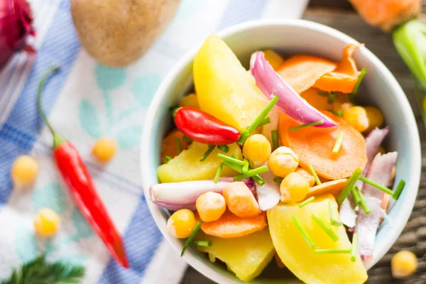 En iyi görünümü nohut salatası sebze ve masa örtüsü ile ahşap arka plan üzerinde ham maddeler