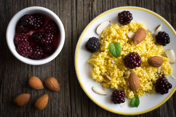 Darı tahıl böğürtlen ve badem ahşap zemin üzerine püre.