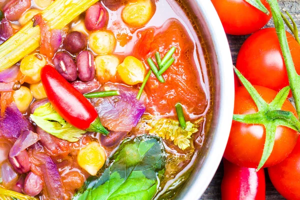 Detail barevné potraviny. Bio zeleninová polévka s cizrna a fazole Adzuki fazole v hrnci s Cherry Tometoes a chilli papričkami — Stock fotografie