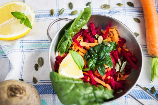 Salada de legumes com beterraba, cenoura, folhas de espinafre e limão Fotografia De Stock