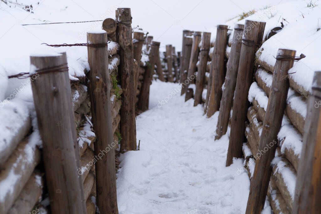Military trenches in winter, walls reinforced with wooden logs