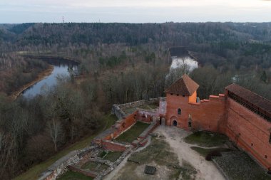Ortaçağ Turaida Şatosu 'nun (Treiden Kalesi) Gauja Nehri' nin arka planında, ormanlarda ve Letonya 'da kışın manzara parkında korunmuş ve yeniden yaratılmış kısımları.