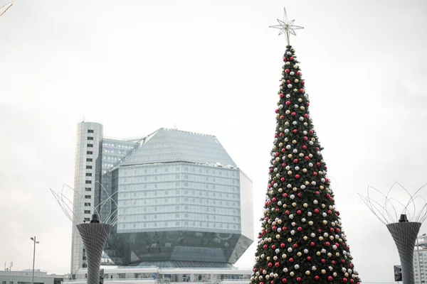 Beautiful city Christmas tree on the background of buildings of the city of Minsk.