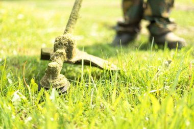 İşçi, çim biçme makinesiyle çim biçiyor. Bir adam çim biçme makinesiyle çimlere bakar..