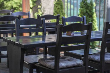 Kahverengi masa ve sandalyeler güneşli bir havada bir bahçe restoranında