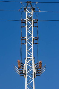 Mavi gökyüzünün arka planında yüksek voltaj kulesi